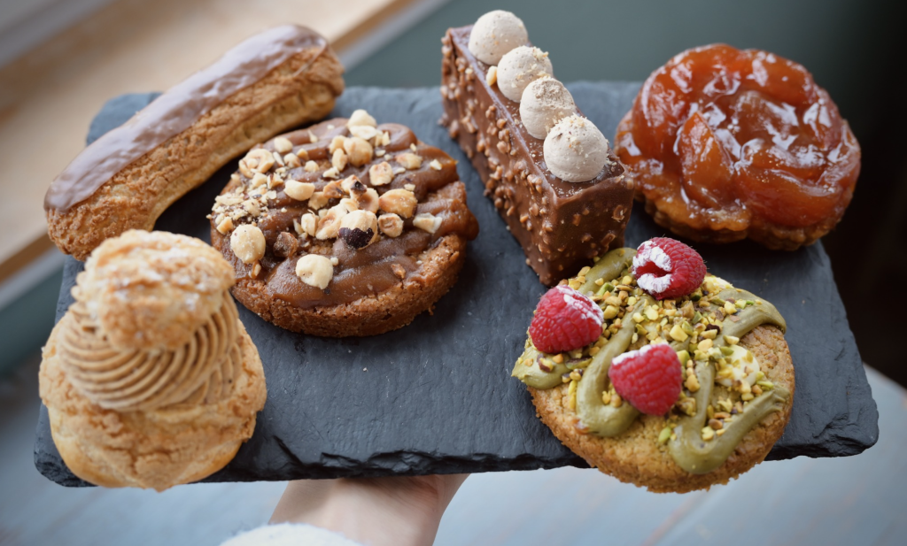 Sélection de pâtisseries artisanales du Comptoir de Saint-Georges : Paris-Brest, éclair au chocolat, tarte Tatin et cookies gourmands